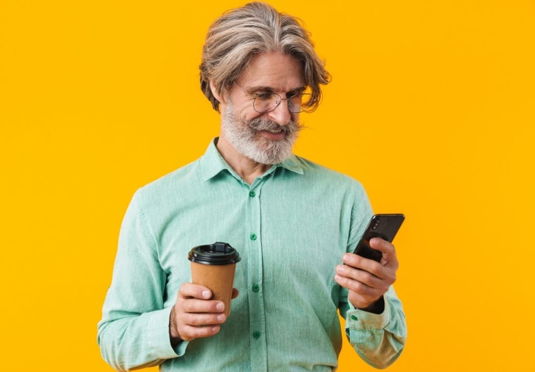 Man on phone holding a coffee